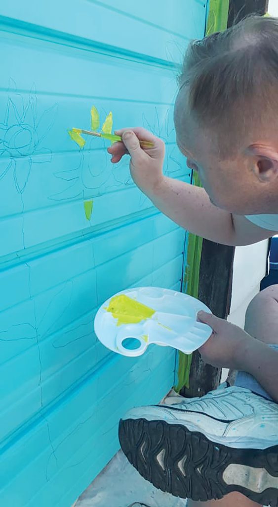 A photo of Paul Knoll painting a garage in Westboro.