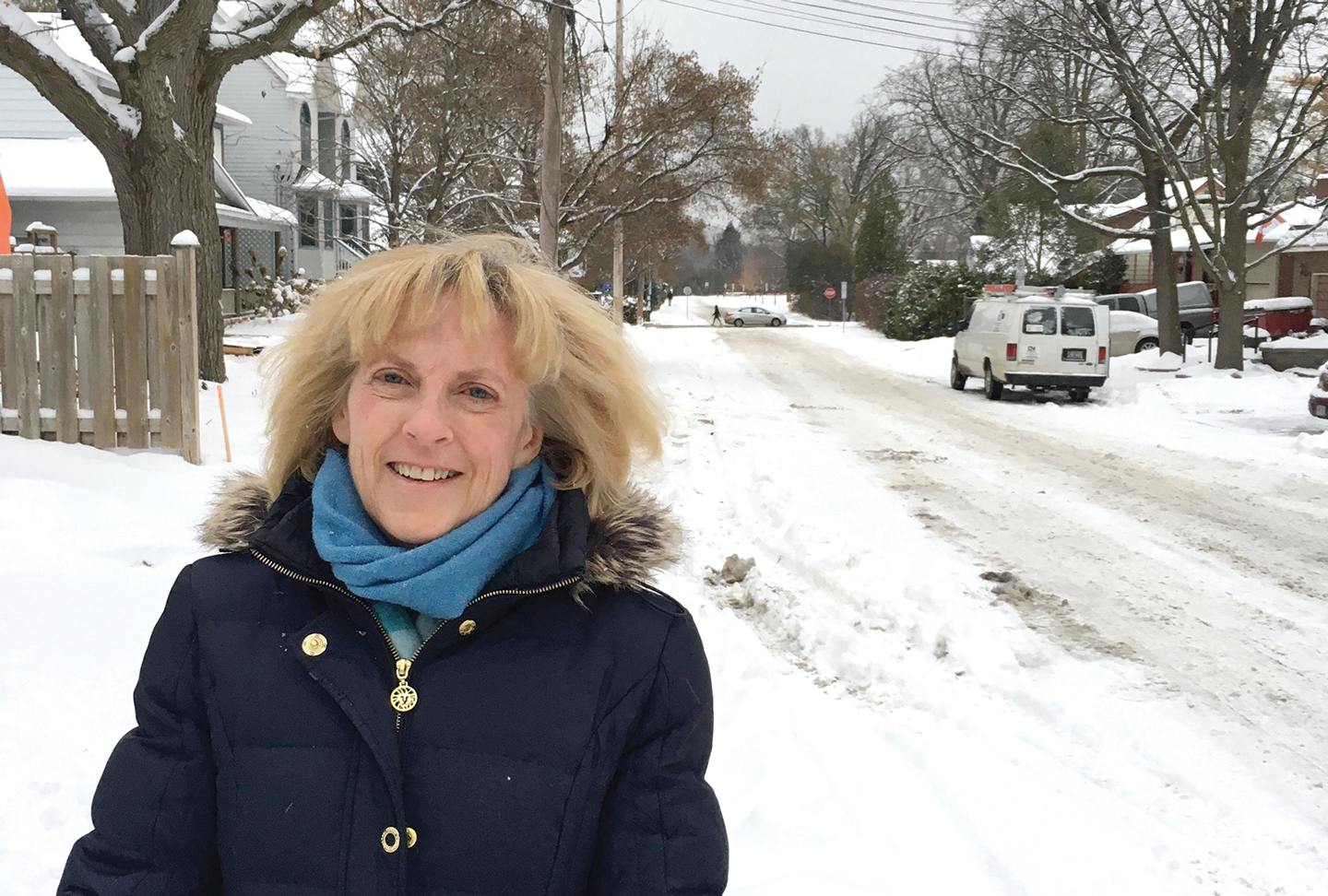 Louise Atkins, a resident of Kitchissippi, stands in front of a snowy street in her neighbourhood.