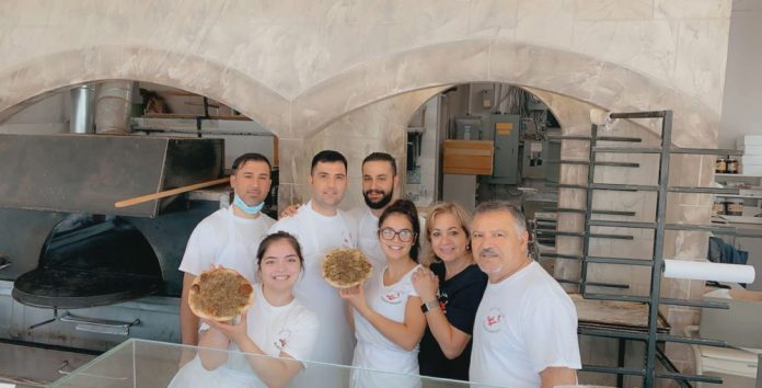 A photo of the staff of Aladdin Convenience & Bakery.