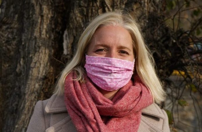 Catherine McKenna standing outside with a mask on in fall