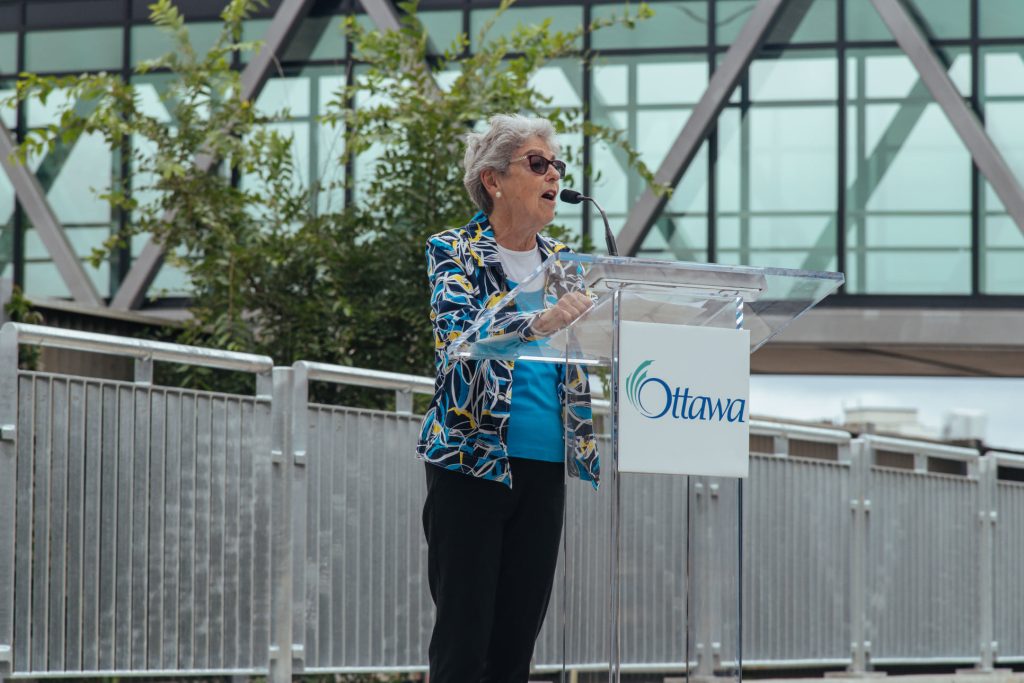 Former Mayor Jackie Holzman speaks at a podium in Ottawa.