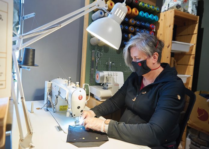 A photo of Cindy Jones sewing a mask in Westboro.|A photo of owner Gareth Davies wearing a mask at Maker House.|A photo of some Canadian-made masks at Maker House in Hintonburg.|A photo of colourful masks at Flock Boutique in Westboro|A photo of Helen Peterson wearing a mask at Flock Boutique in Westboro.|A photo of colourful masks made by Cindy Jones in Westboro.|A photo of Cindy Jones sewing a mask in Westboro.