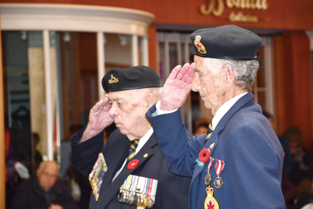 Two veterans saluting at the Carlingwood Mall Remembrance Day ceremony in Ottawa on Nov. 11, 2019.