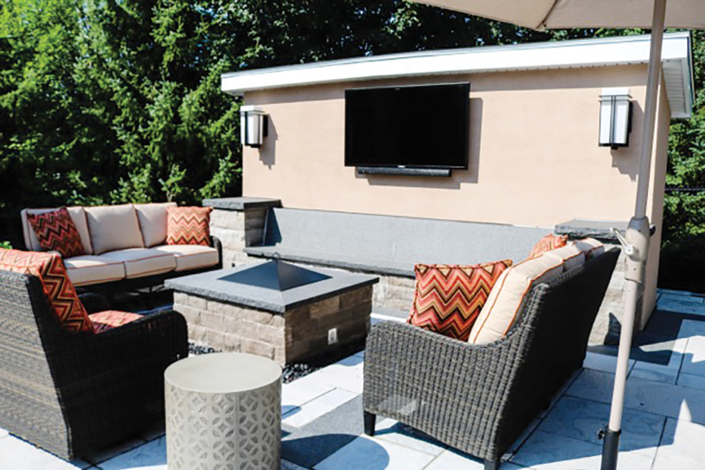 A photo of an outdoor living room with a television and outdoor couches.