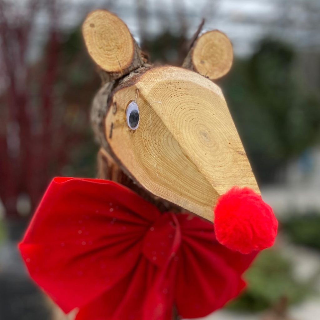 A wooden deer with a red nose stands at Parkdale Market.