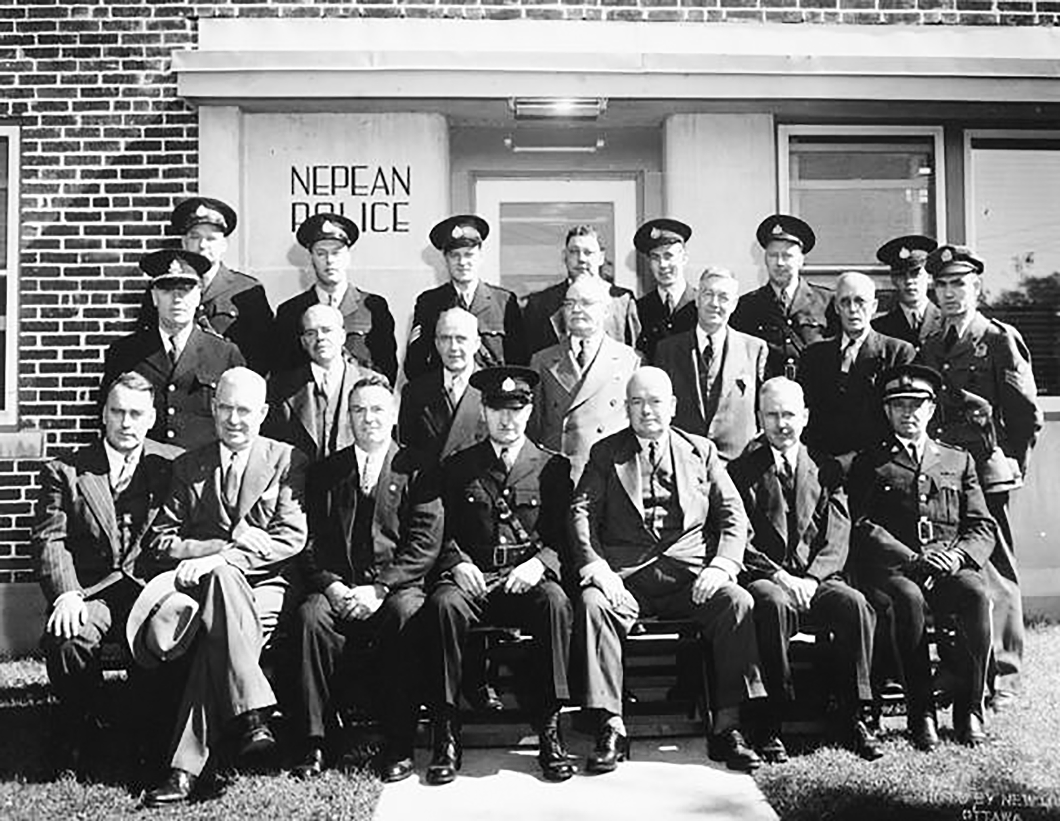 A black and white group photo of the Nepean police taken outside the station in 1947.