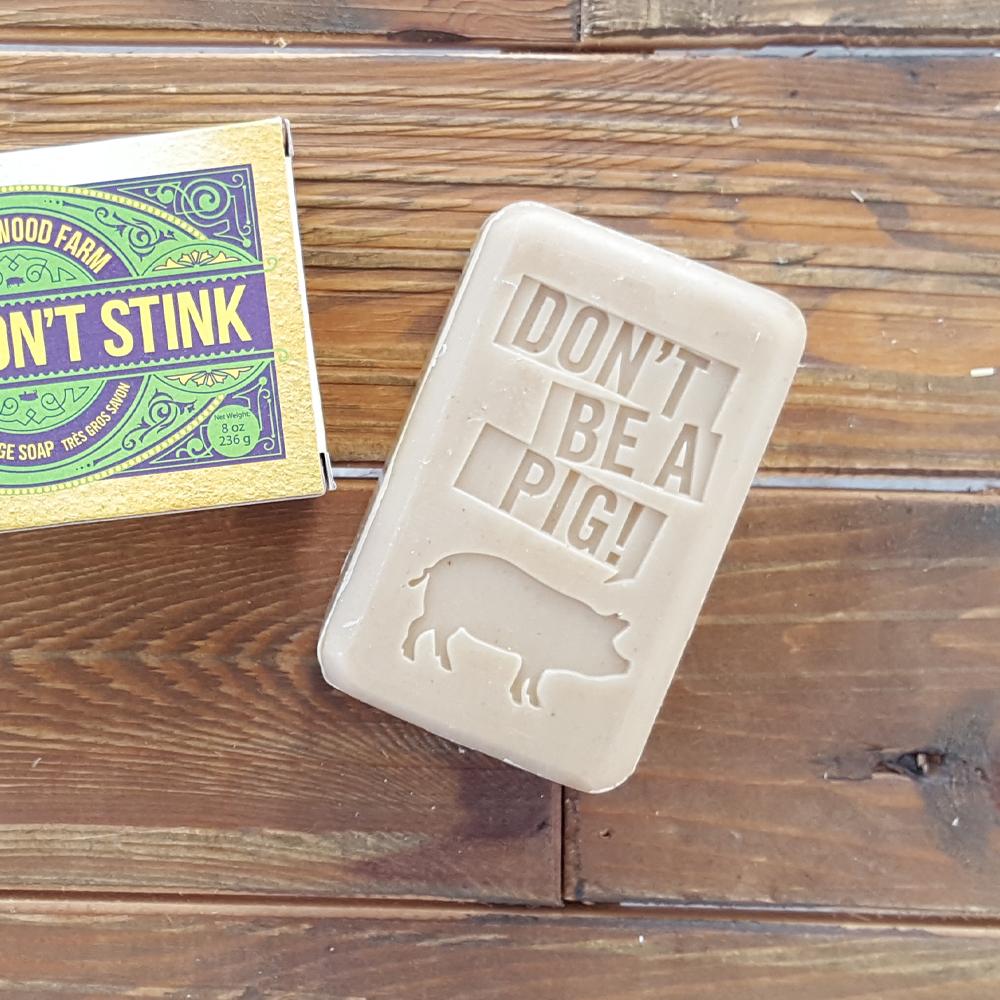 A white bar of soap with the words "Don't Be A Pig!" stamped in.