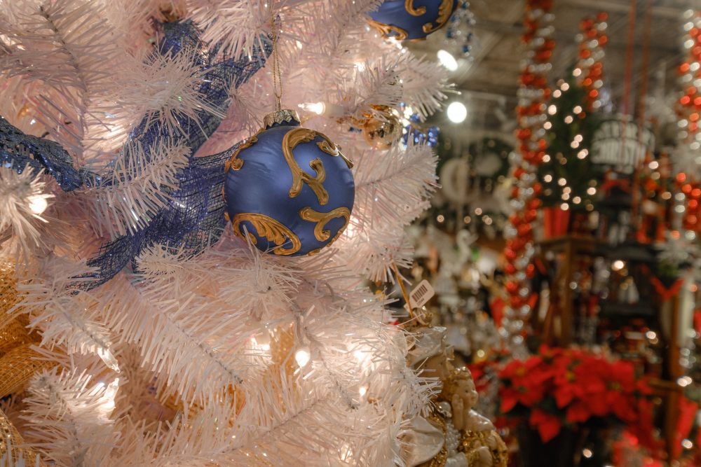 A blue ornament hangs on a white tree at Tinseltown