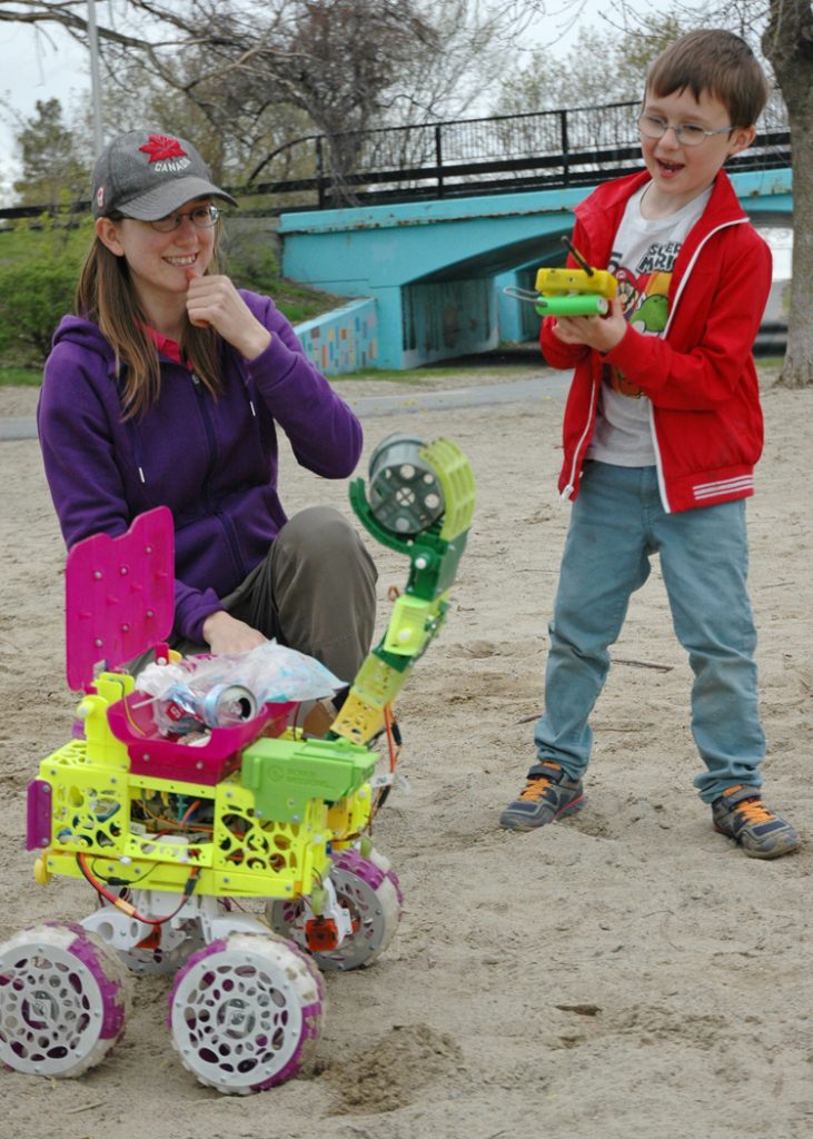 Miles Columbus marvels as he controls the beach cleaning bot, nicknamed Bowie, to pick up discarded trash.