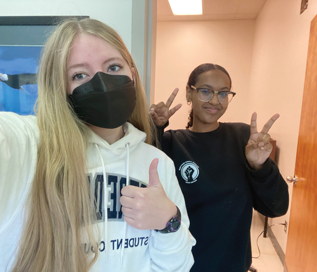 Two female students stand side by side in a self-taken photo.