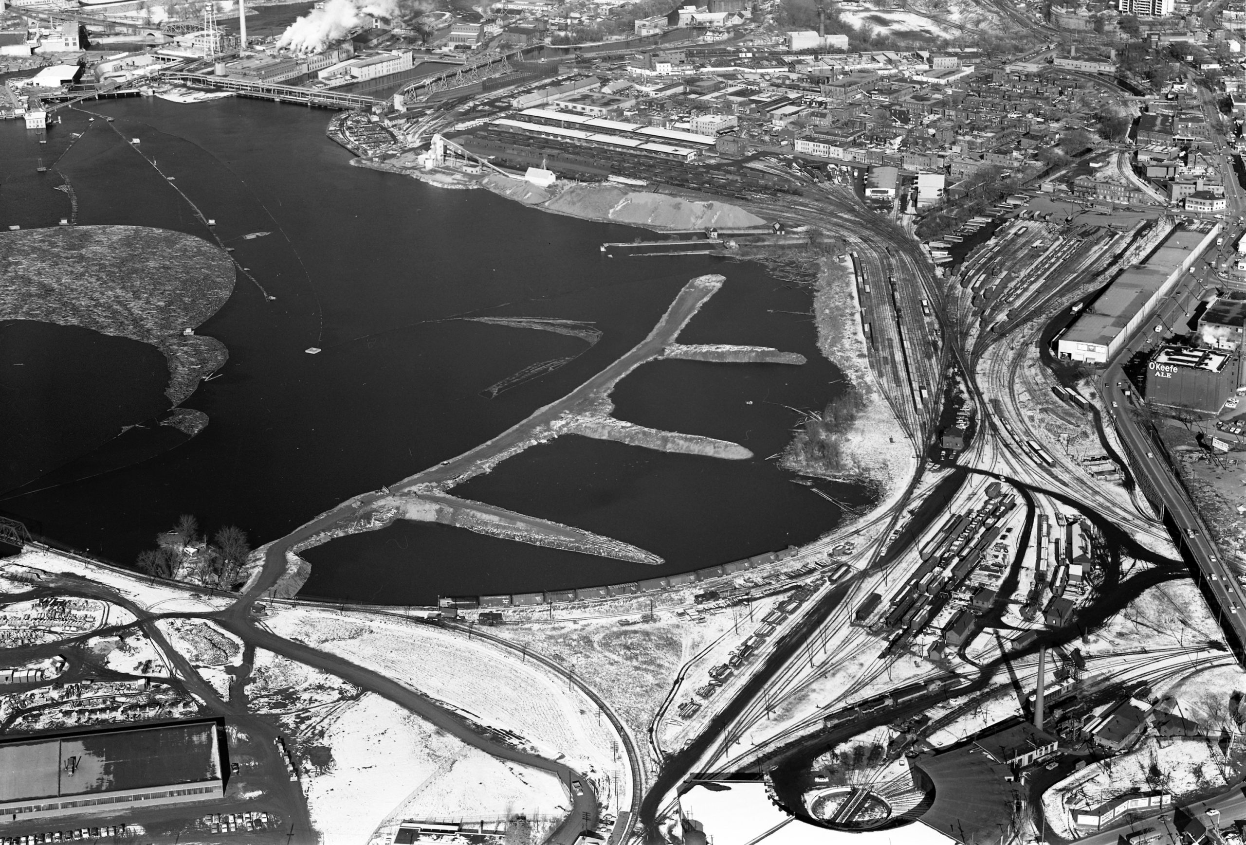 A black and white aerial photograph of the causeway under construction. 