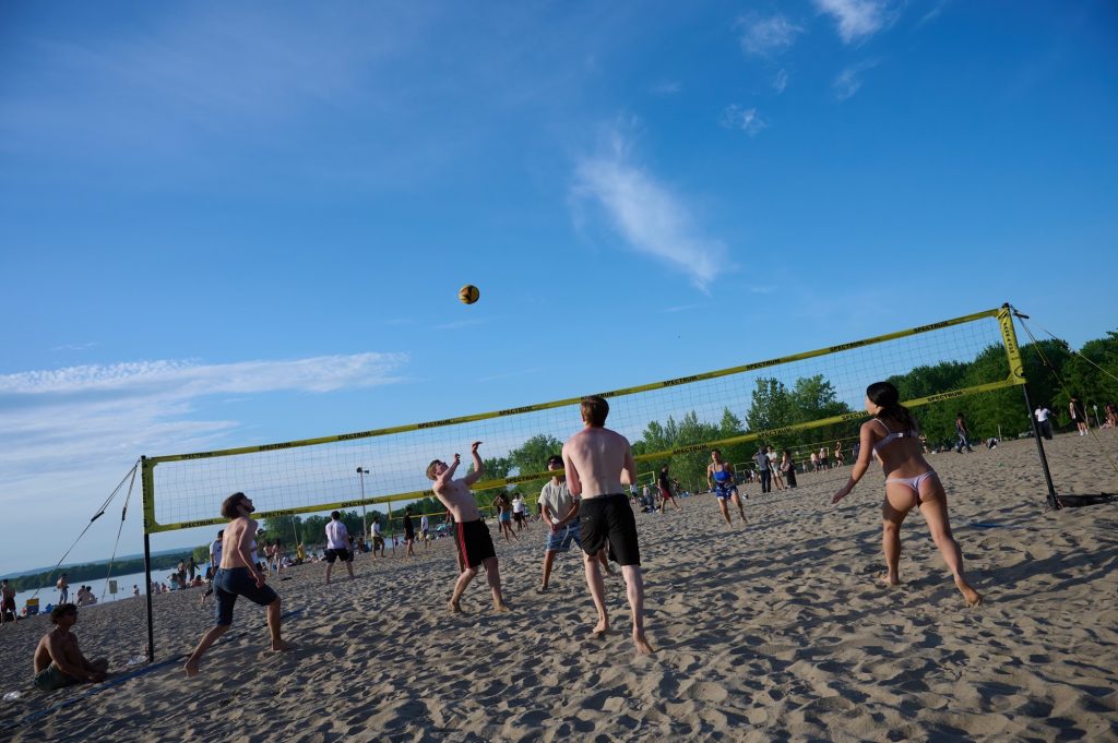 A group of people play a game of volleyball. 