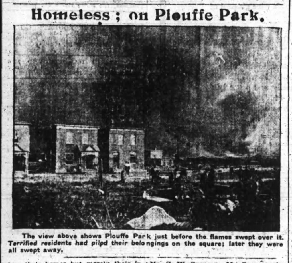 A grainy photo showing smoke billowing over Plouffe Park. Two houses still standing can vaguely be seen in the distance. 