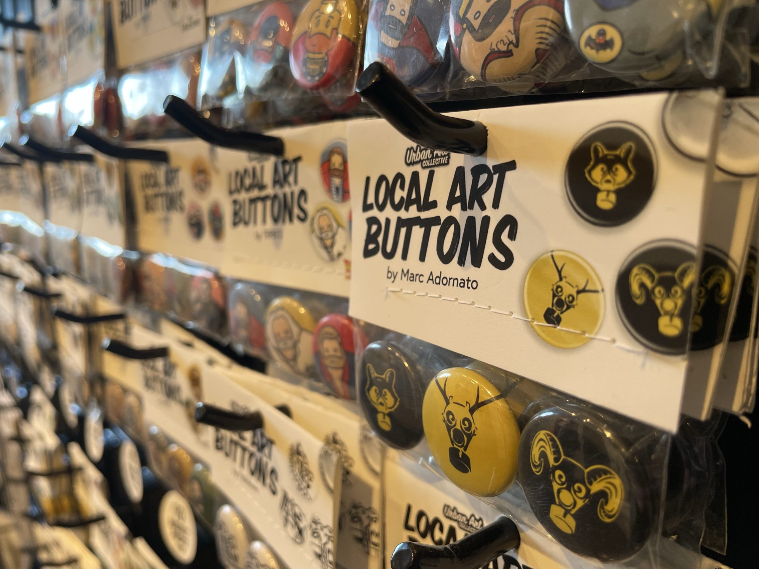 Local artists pins for sale on a rack.