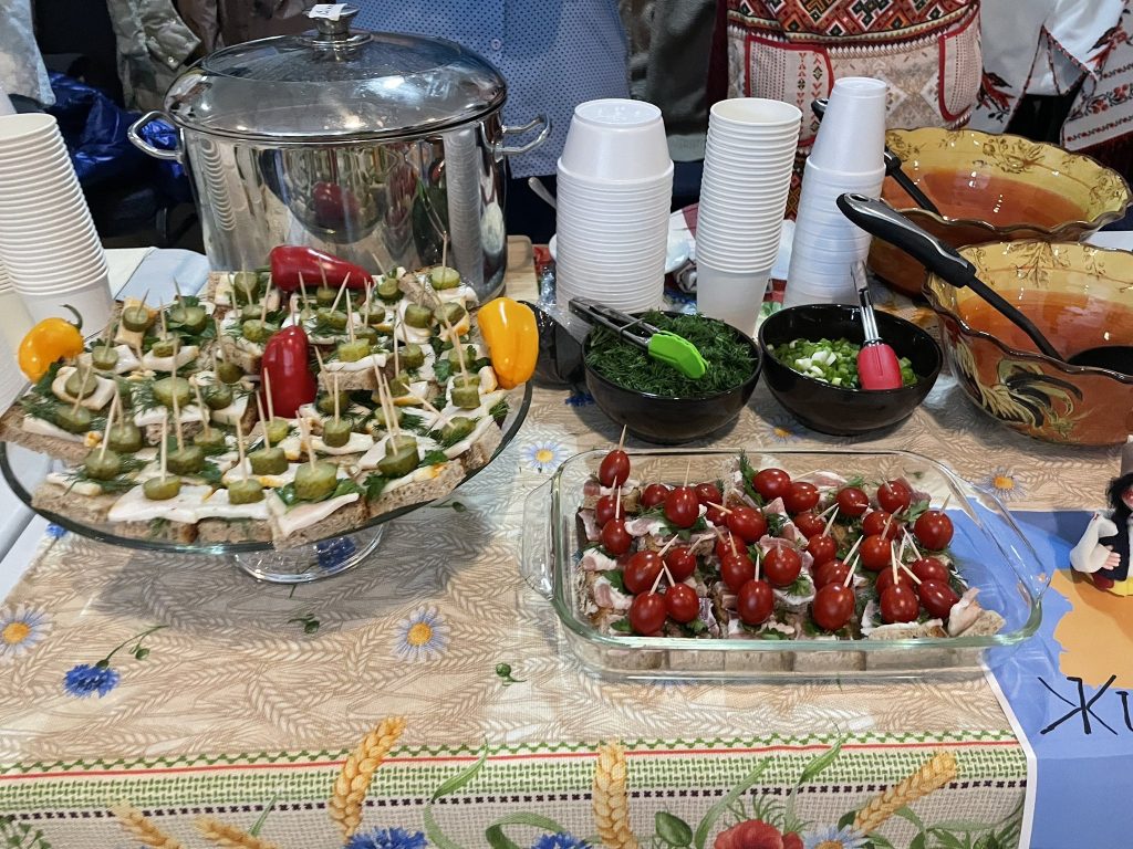 Some vegetables and food dishes are displayed on a table. 