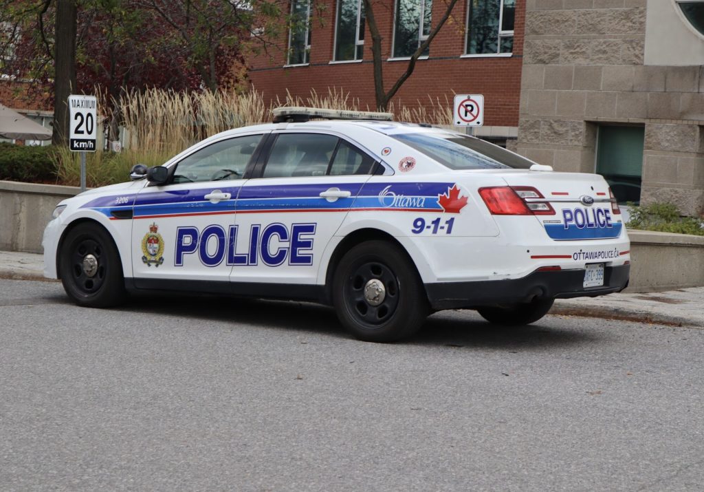 A police cruiser parked outside of a building. 