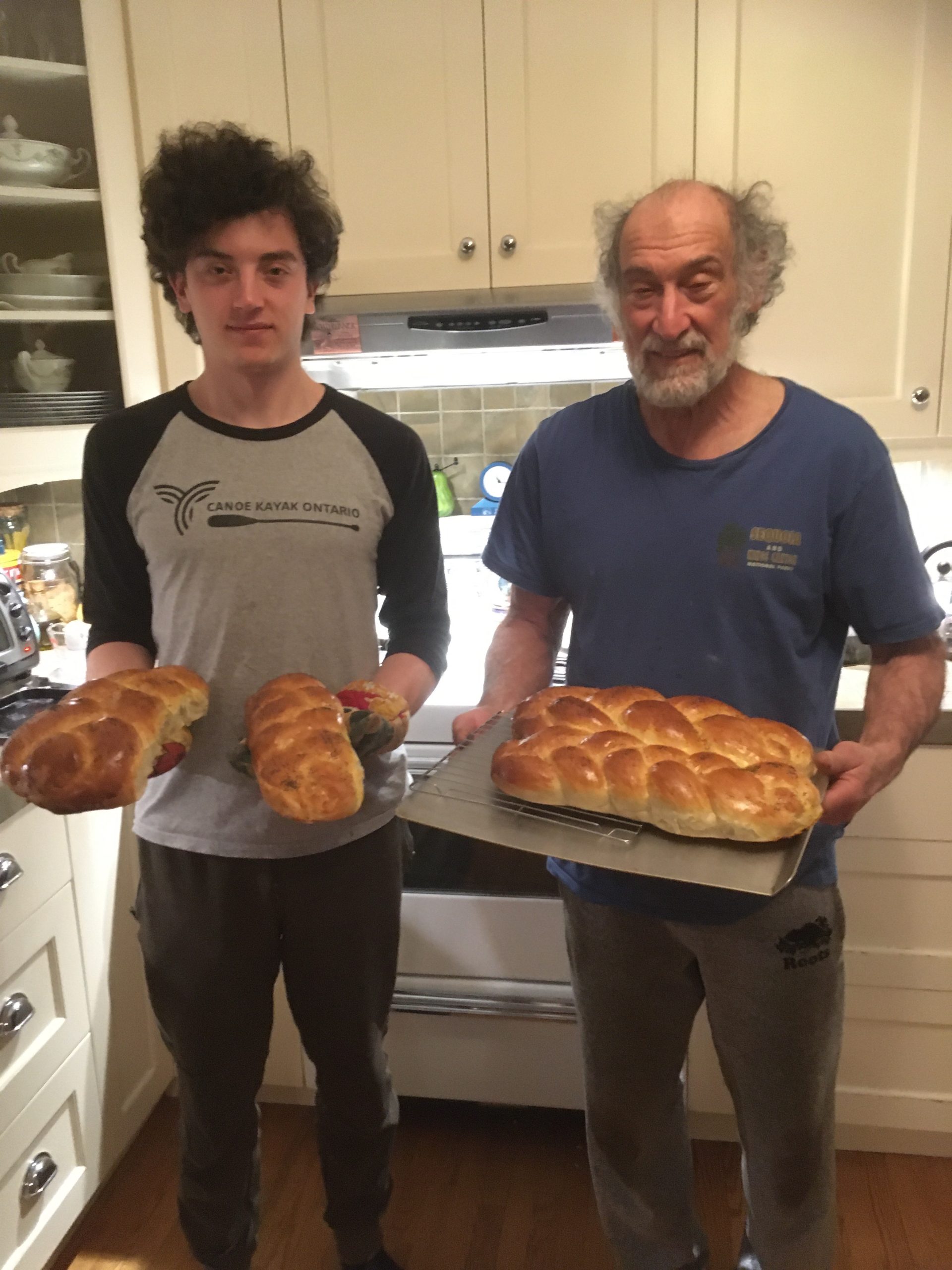 Max and Isaac pose for a photo in the kitchen with fresh challah bread out of the oven.