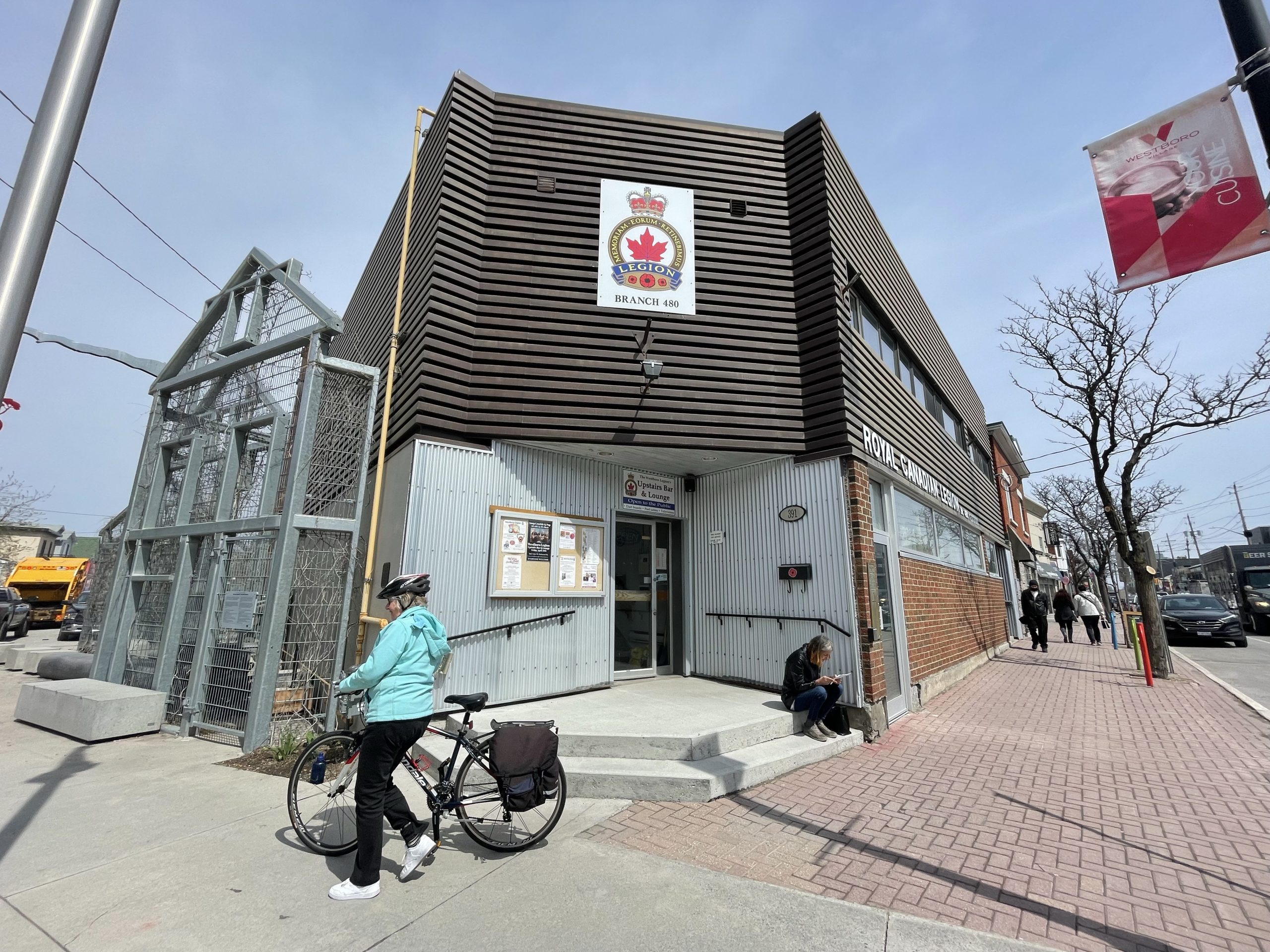 The exterior of Westboro Legion. A woman walks by with her bike.