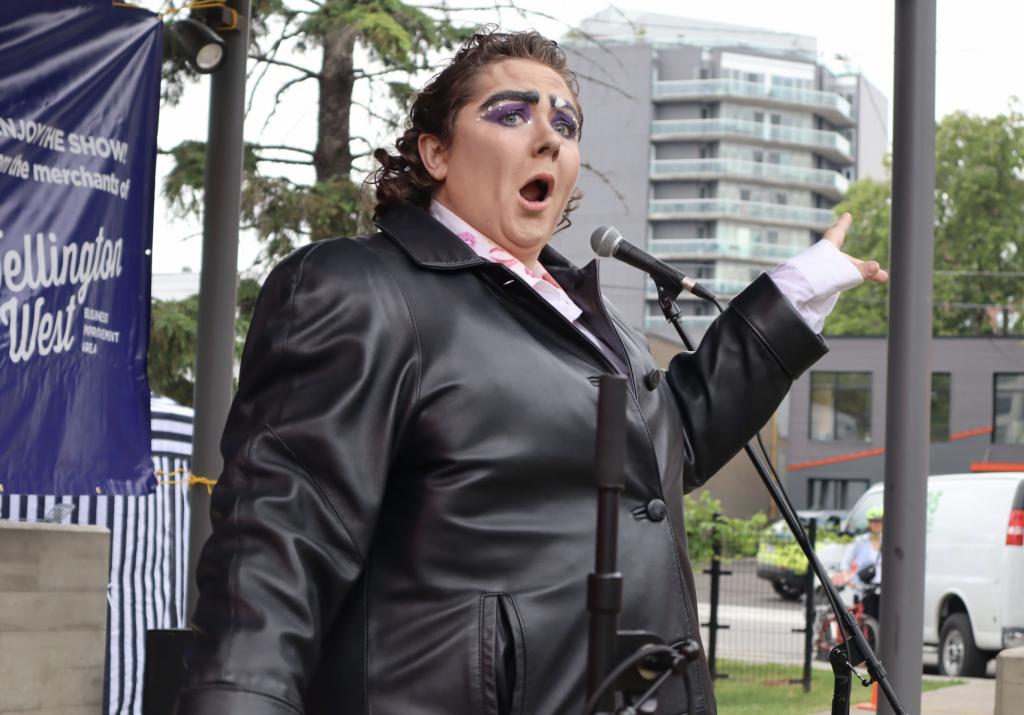 A drag king performs on stage. 