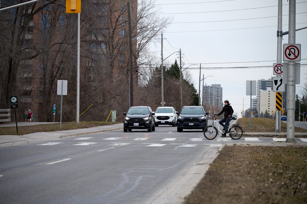 A bike crosses the street at Carling. 