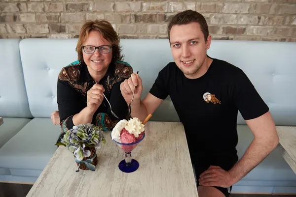 Tammy and a man sit at a booth inside Stella Luna. 