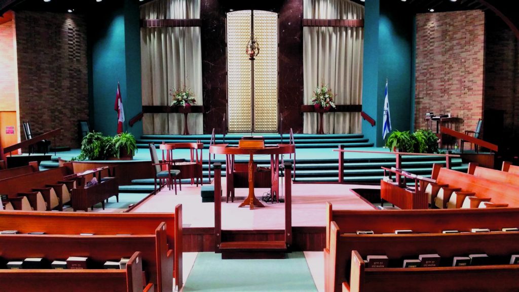 The interior of the church with benches on both sides and an alter in the middle. 