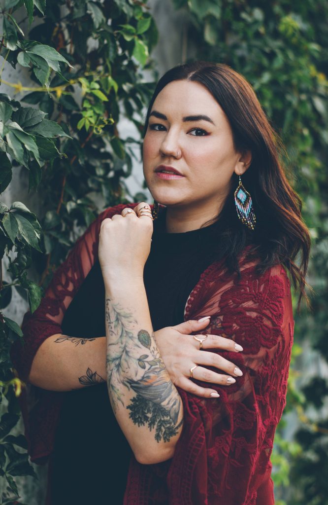 A professional headshot of Karen McBride in front of a leafy background