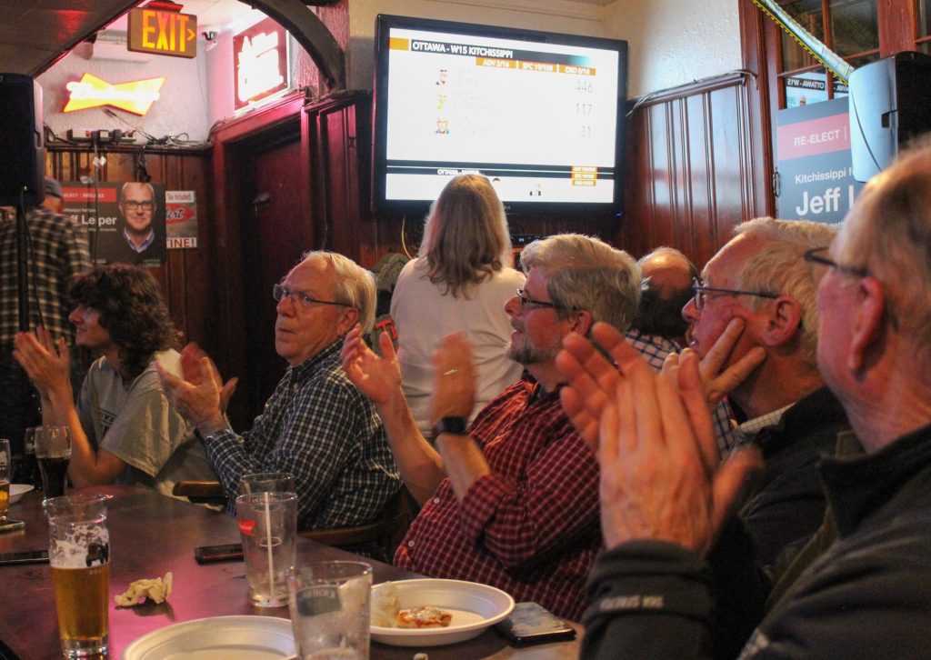 A number of people clap their hands after a man gives a speech.