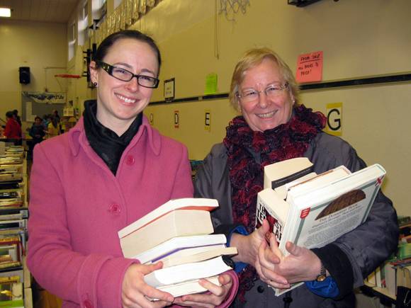 Barbara Lance (right), of Mayfair Avenue, invited daughter Elizabeth Lance, now of Gatineau, to BookFest. “I wouldn’t miss this for anything,” says Elizabeth. Barbara says: “I bought murder mysteries for summer reading, and non-fiction coffee table books to support my family history habit.” Elizabeth tracked down novels, books about dogs and business books, including Seth Godin’s <em>Purple Cow</em>, but says she’s most looking forward to rereading John Grogan’s <em>Marley and Me.</em> “I already have this in digital format, but there’s no substitute for a real book.” Photo by Denise Deby.