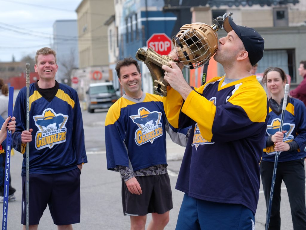 Dave Allston of The Gamblers embraces victory as his teammates – Derek Smith, John Holland, and Kristen Couture – look on.