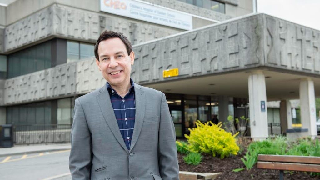 A photo of Alex standing outside of the hospital.