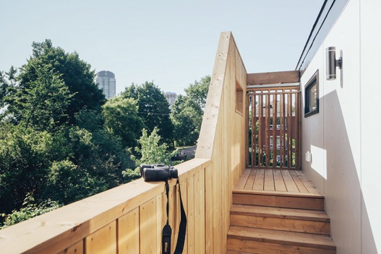 A wooden deck which overlooks trees. The Westboro skyline is seen in the distance.