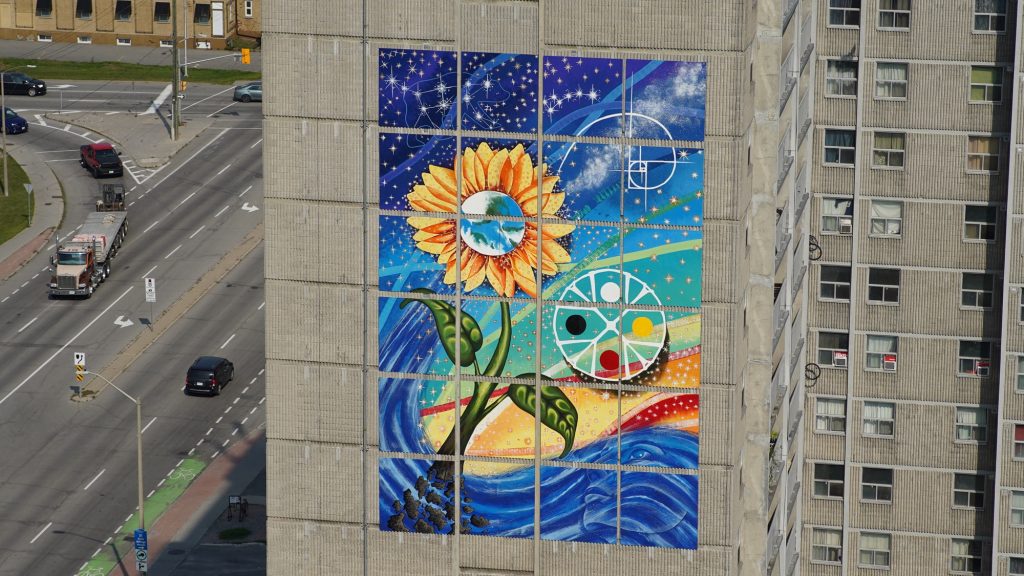 A large mural of a sunflower on a building.